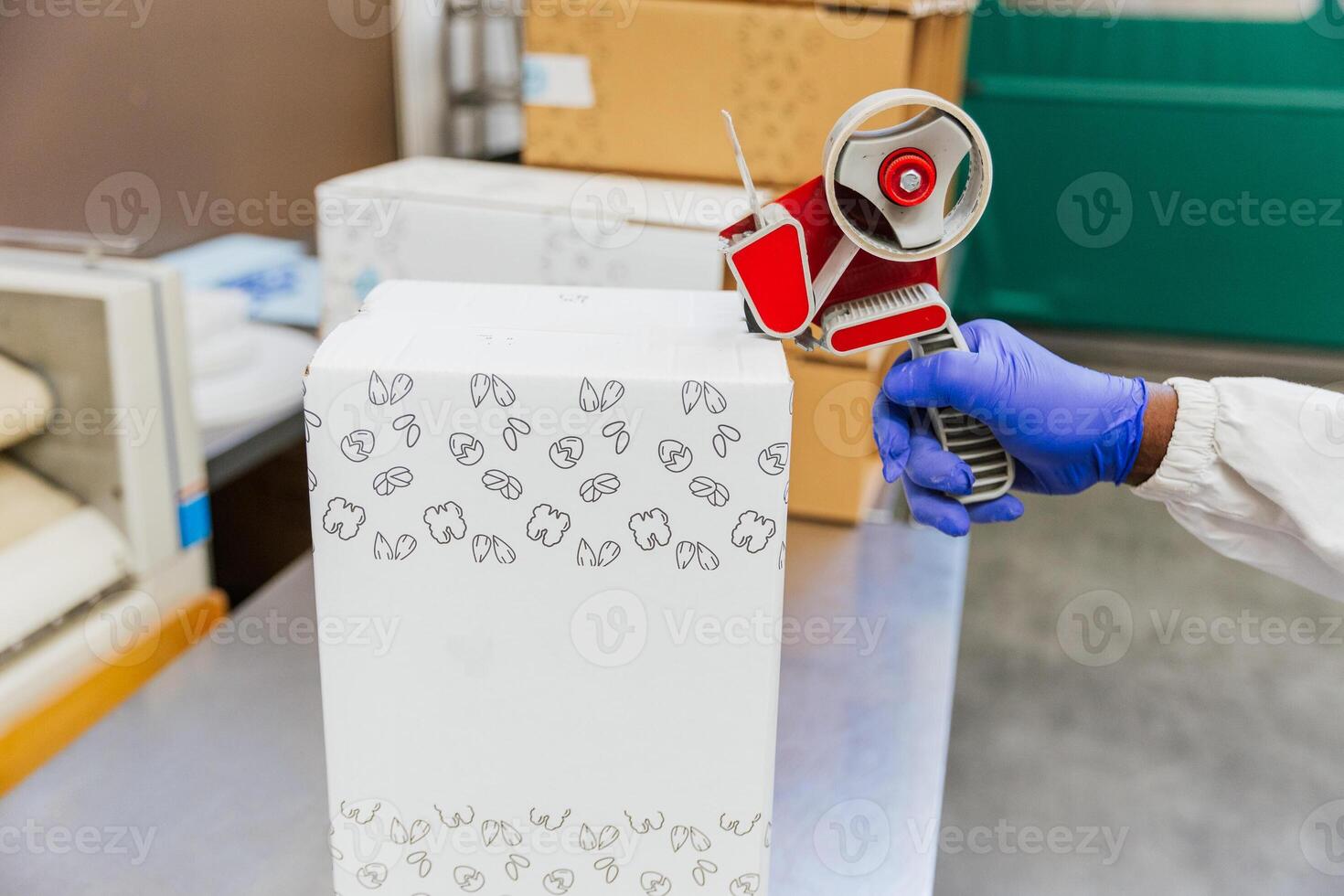 Close up of warehouse worker's hands taping a cardboard box during packaging photo