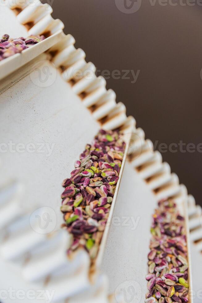Close up of pistachios on a food production line, vertical photo