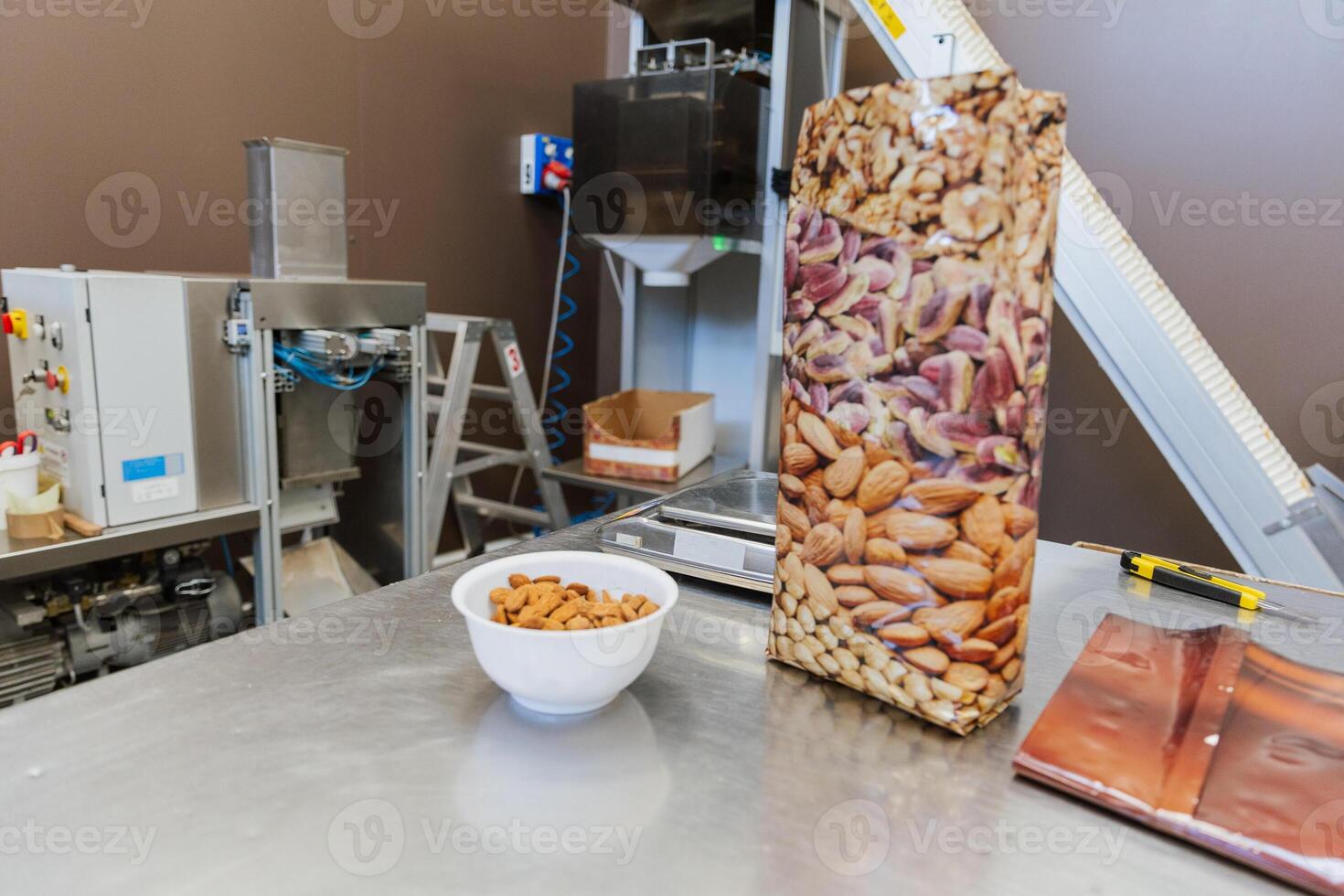 A bowl of almonds next to a plastic bag during the process of packaging photo