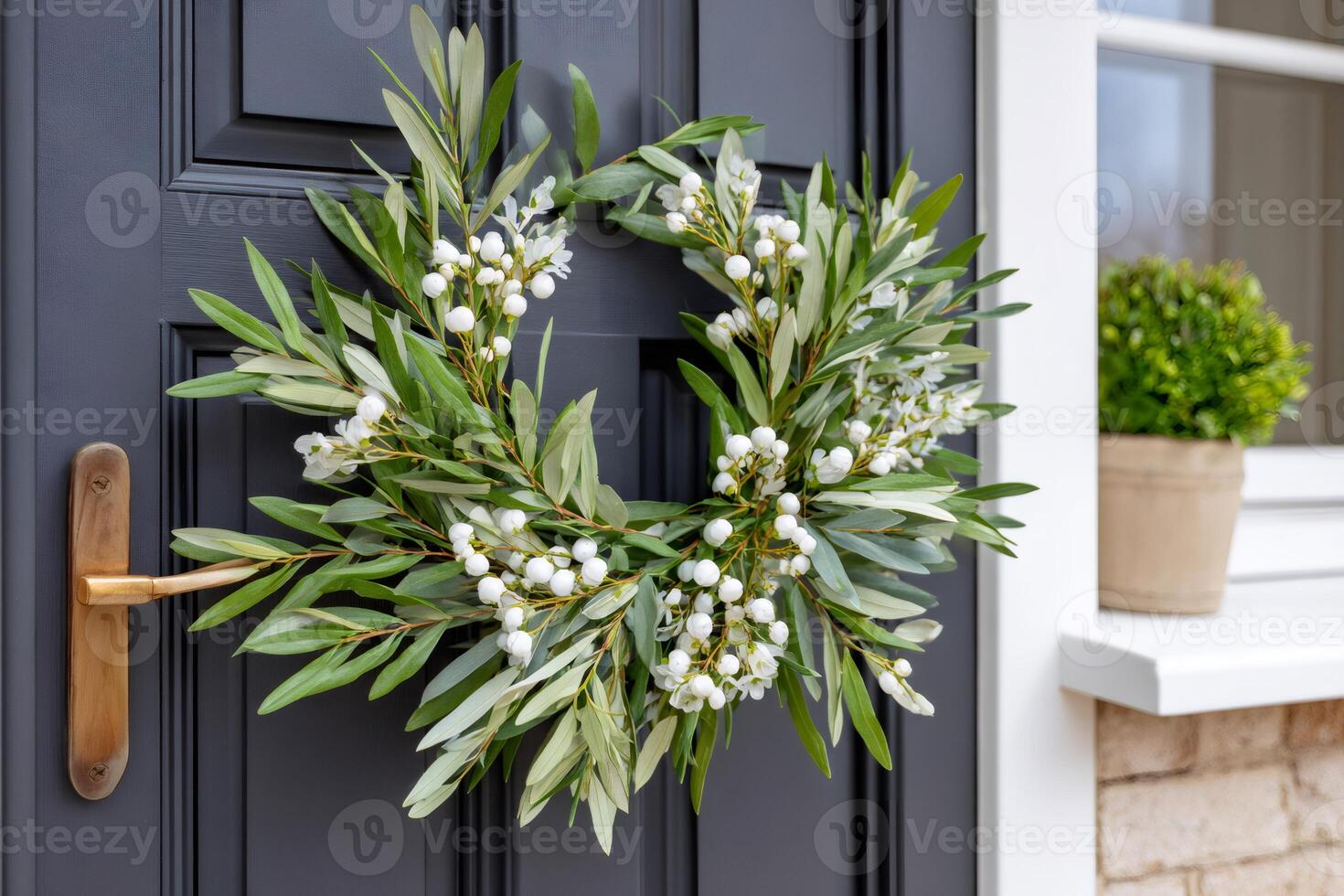 Beautiful olive branch wreath with snowberries hanging on a gray front door photo