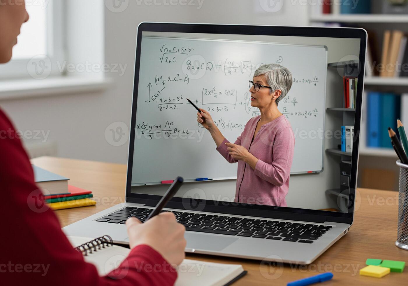 A woman is writing on a whiteboard while sitting at a desk photo