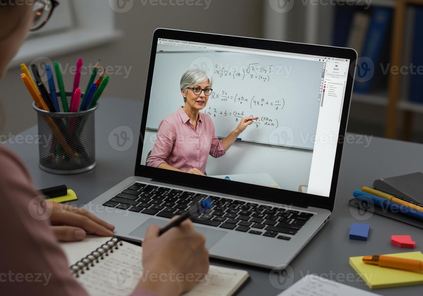 A woman is using a laptop to teach a math lesson photo