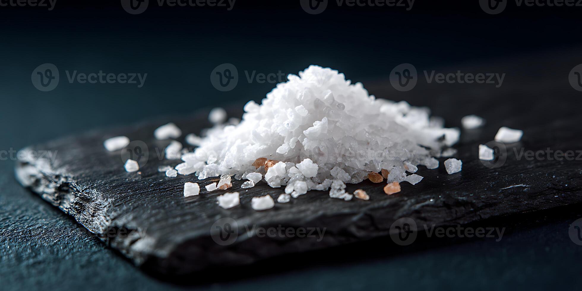 Flat Lay of Salt on black stone plate. photo