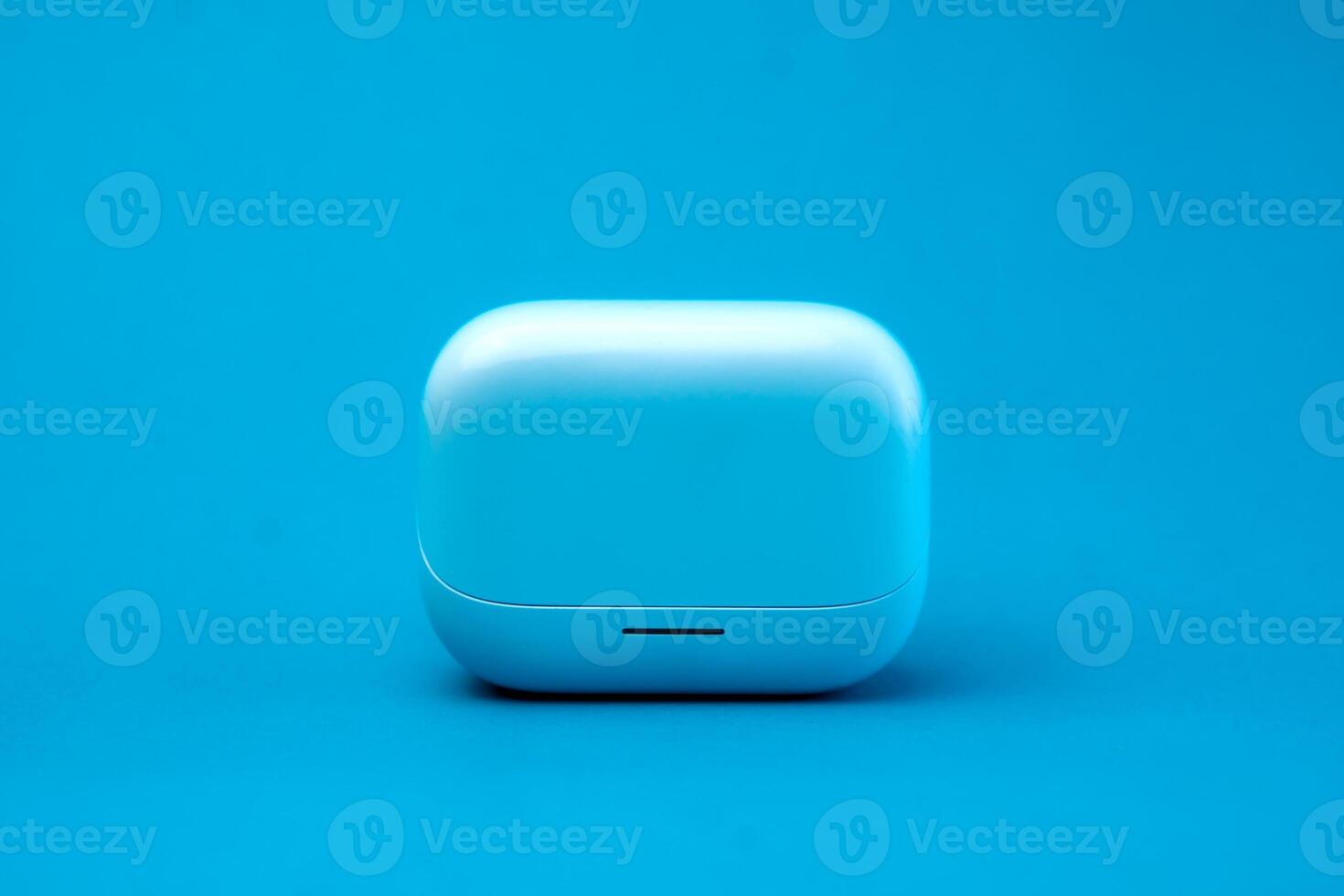 A modern wireless earbuds charging case in a sleek blue design, isolated on a vibrant blue background. Compact, lightweight, and stylish, perfect for travel and daily use. photo