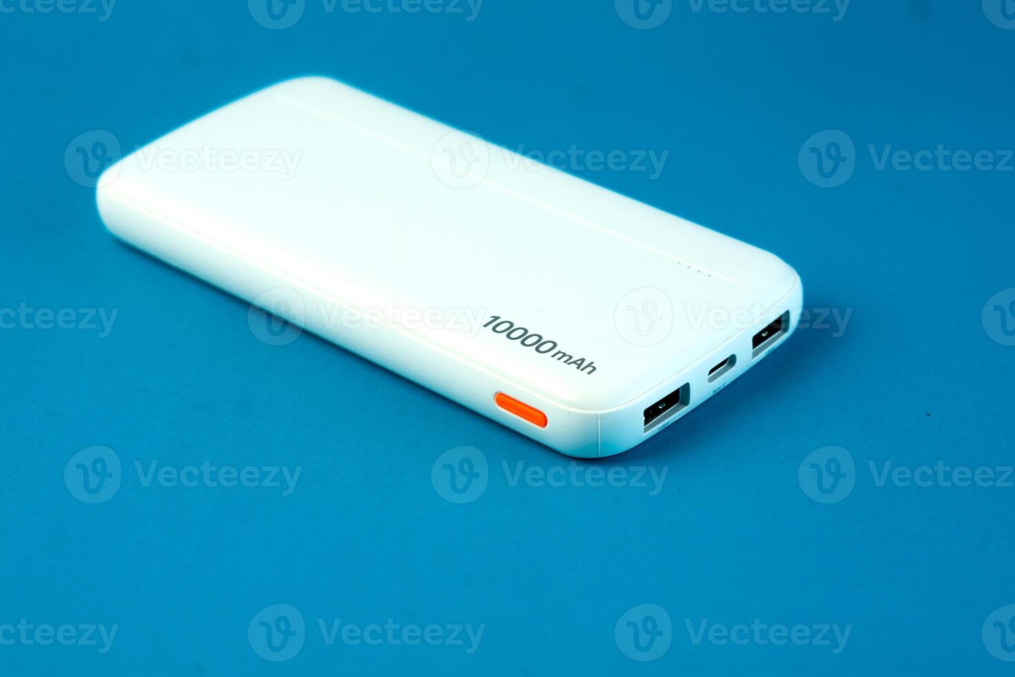 A white 10000mAh portable power bank with dual USB ports and a Type-C input on a blue background. Ideal for charging smartphones, tablets, and electronic devices. Compact and travel-friendly. photo