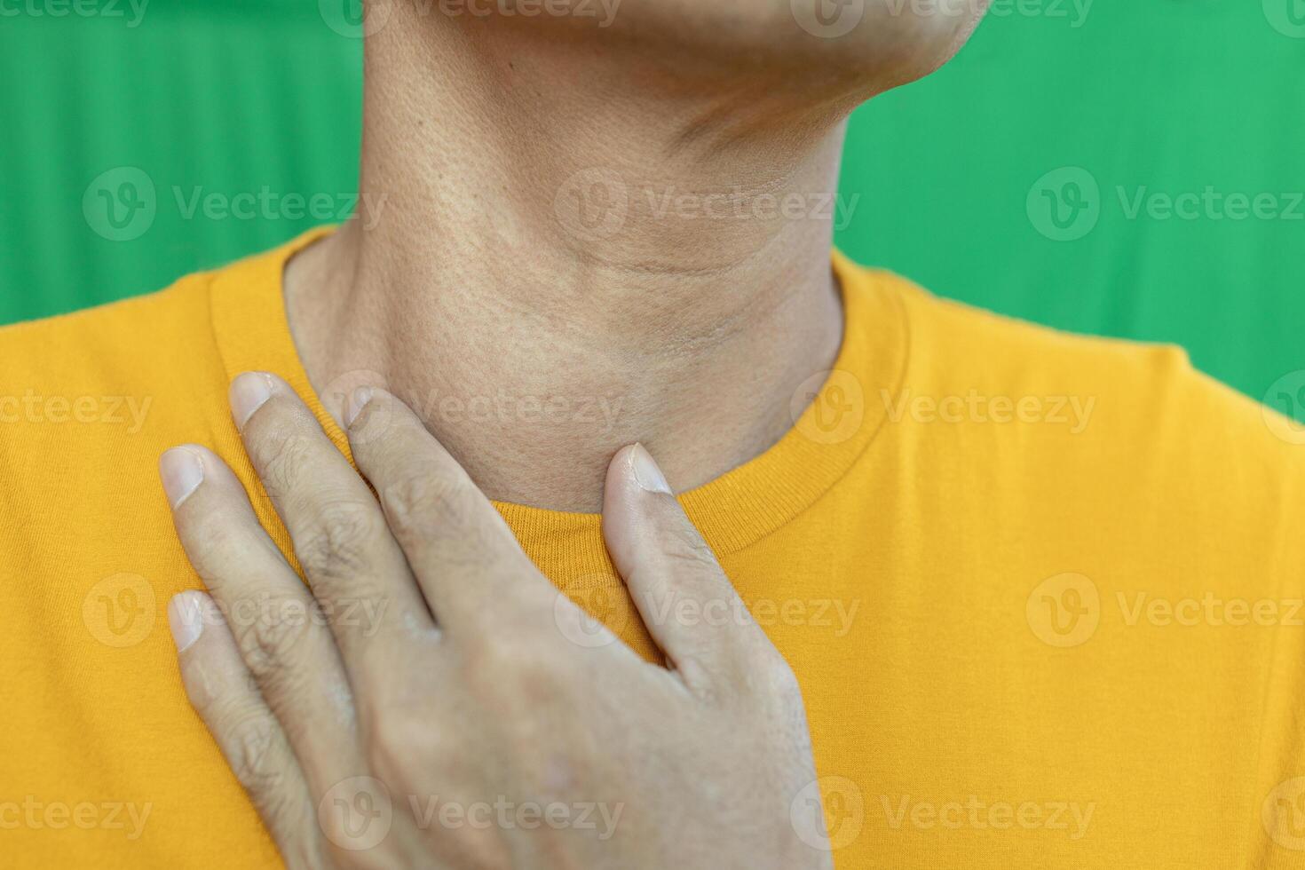 Thyroid gland inflammation at neck. goiter, throat cancer, sore throat and cough, man with neck pain on green, neck health problems concept photo