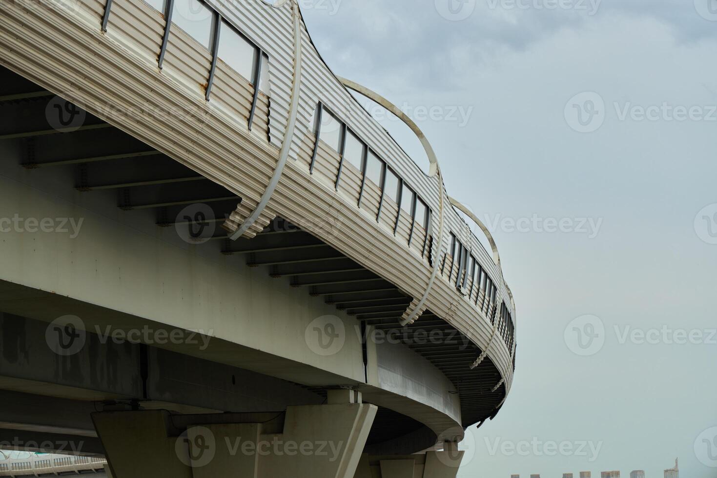 The modern elevated railway structure beautifully contrasts against a dramatic cloudy sky above photo