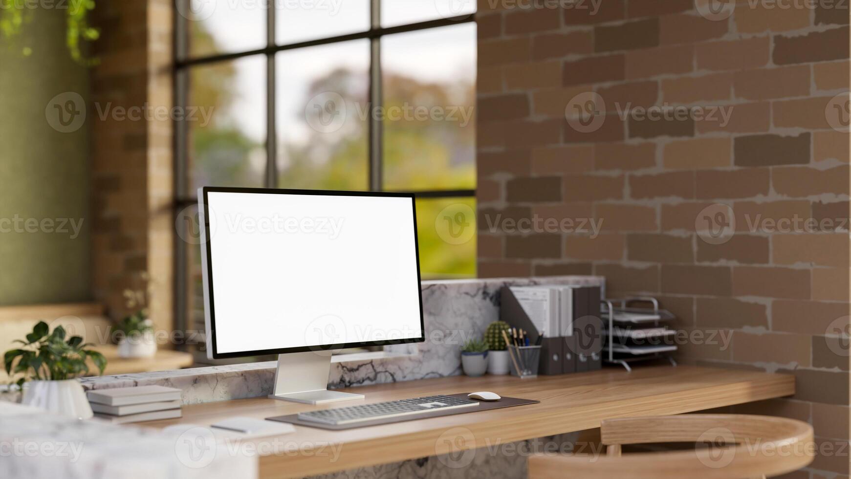 The white screen computer on marble laminate wooden working desk in an office with brick wall. photo
