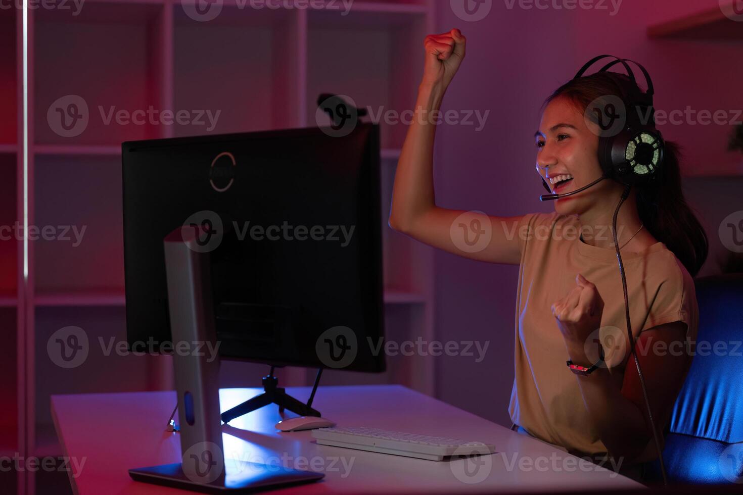Victorious Gamer Celebrating Success. Young woman with headset expressing joy in gaming. photo