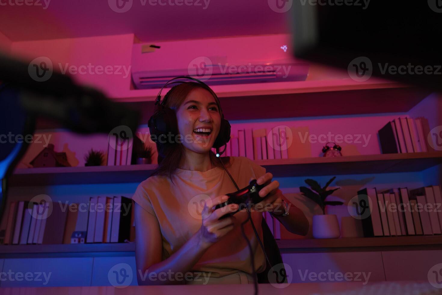 Gaming and Digital Entertainment. Young woman enjoying games in a vibrant, colorful setting. photo