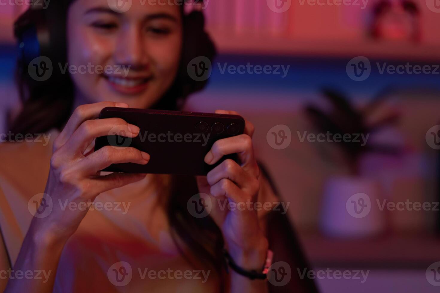 Content Gamer Smiling While Playing Mobile Game photo