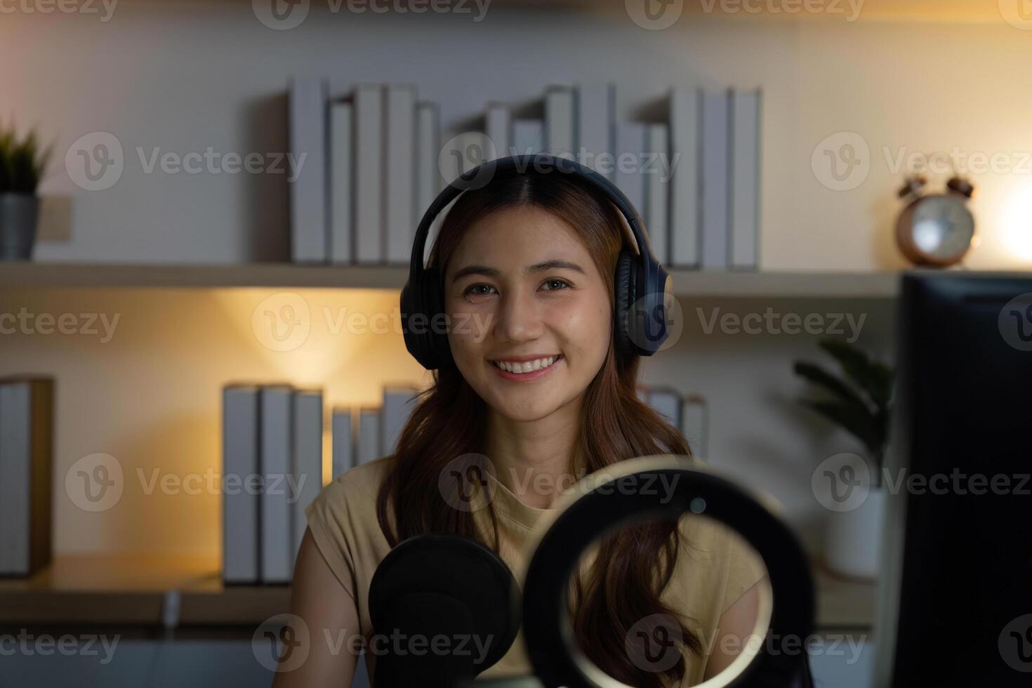 Remote Work and Digital Engagement. Young woman in headphones smiling while streaming online. photo