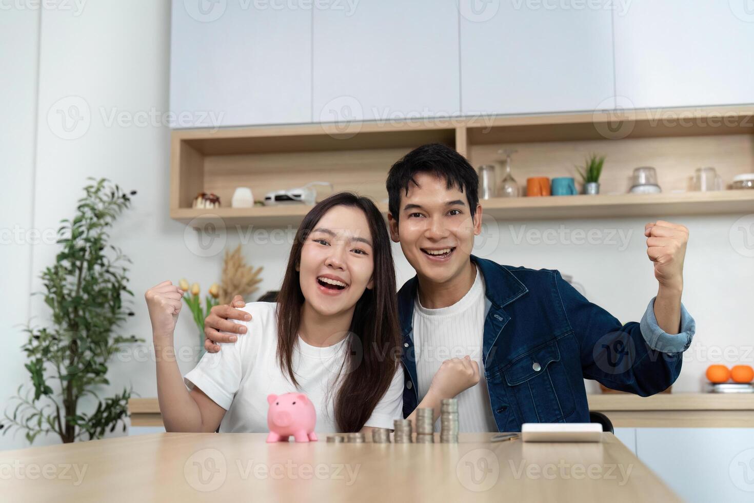 Financial Success and Celebration. Happy couple celebrating savings at home. photo