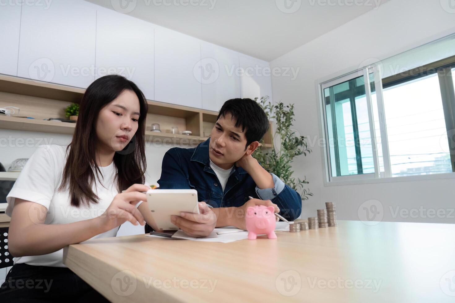 Couple Analyzing Finances. Young adults reviewing budget on tablet at home. photo