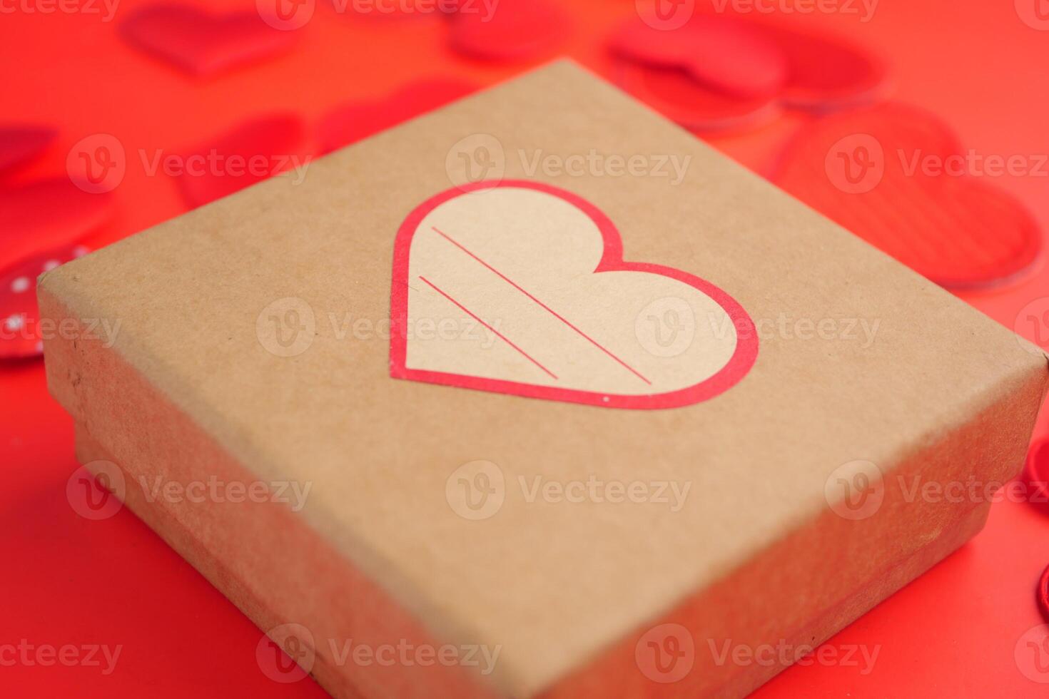 Gift box with heart design on a vibrant red background photo
