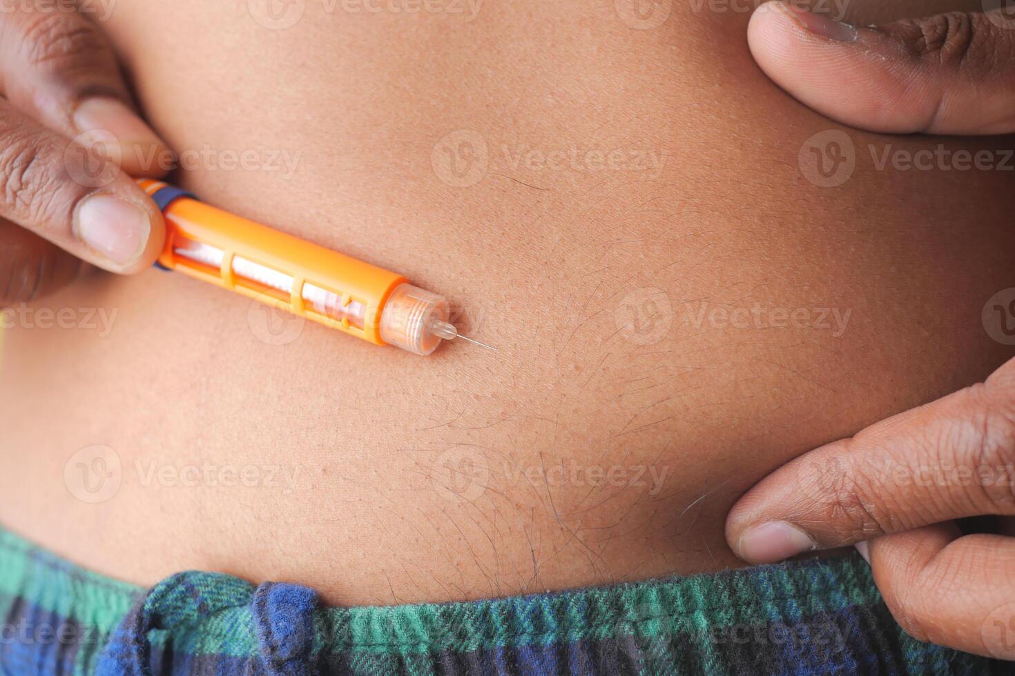 Person inject insulin in his abdomen photo