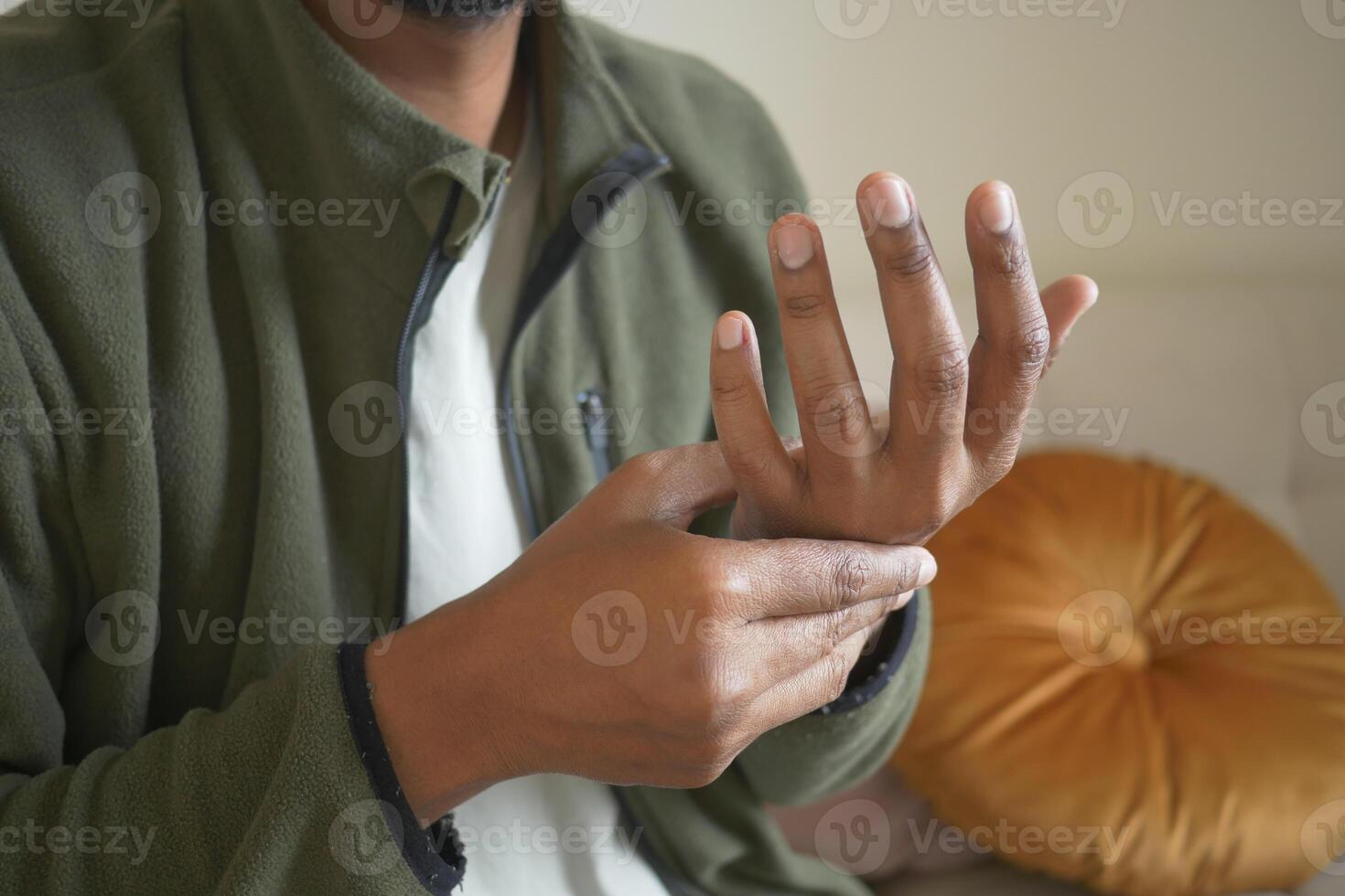 Person with wrist discomfort while sitting indoors photo