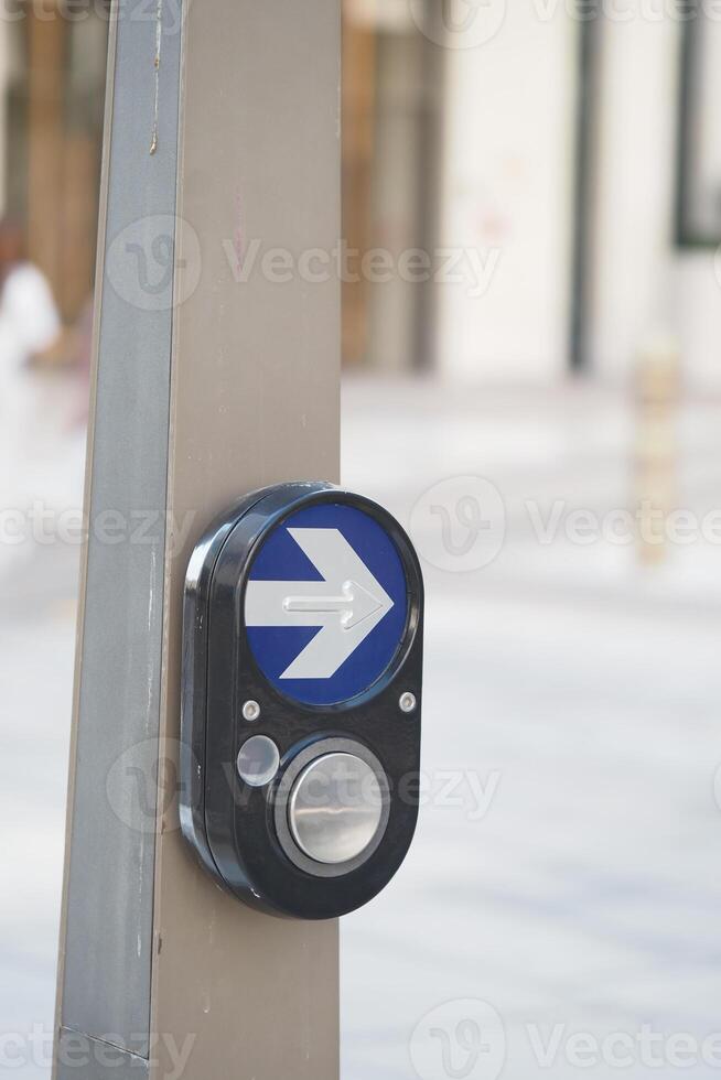 Button for pedestrian crossing in urban setting photo