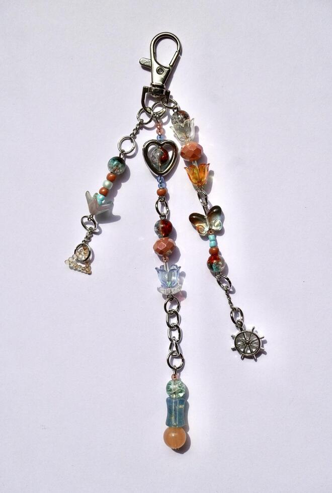 Beautiful handmade brown and blue colored beads bag charm isolated on vertical white background. photo