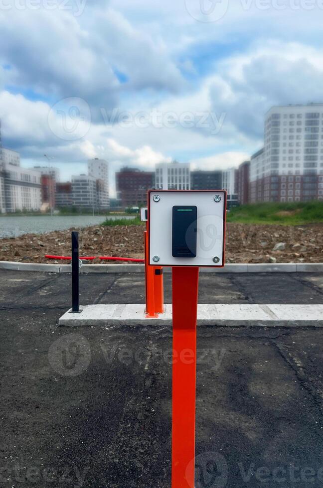 Modern urban landscape featuring a sleek black device for security parking system , with a blurred city skyline and cloudy sky in the background, showcasing contemporary infrastructure photo