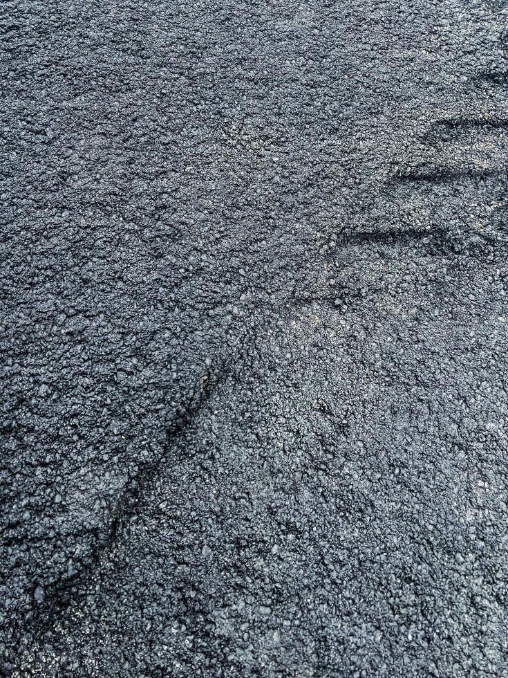 Close-up view of freshly laid asphalt surface, showcasing textured black material with visible aggregate, durability and quality of road construction photo