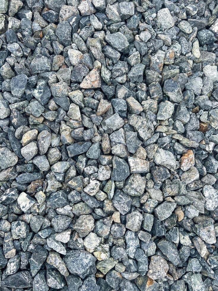 Close-up view of various sizes of gravel stones, showcasing a mix of gray and earthy tones, highlighting texture and natural patterns in a construction material setting, natural background photo