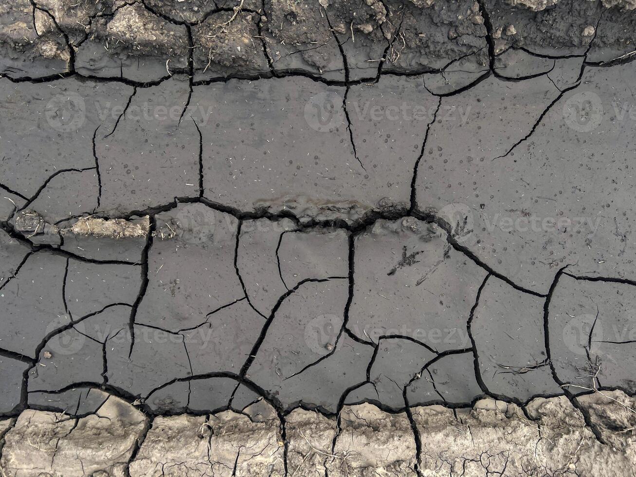 Cracked earth surface displaying intricate patterns of dry soil, showcasing the effects of drought and environmental changes on natural landscapes and ecosystems, natural background photo
