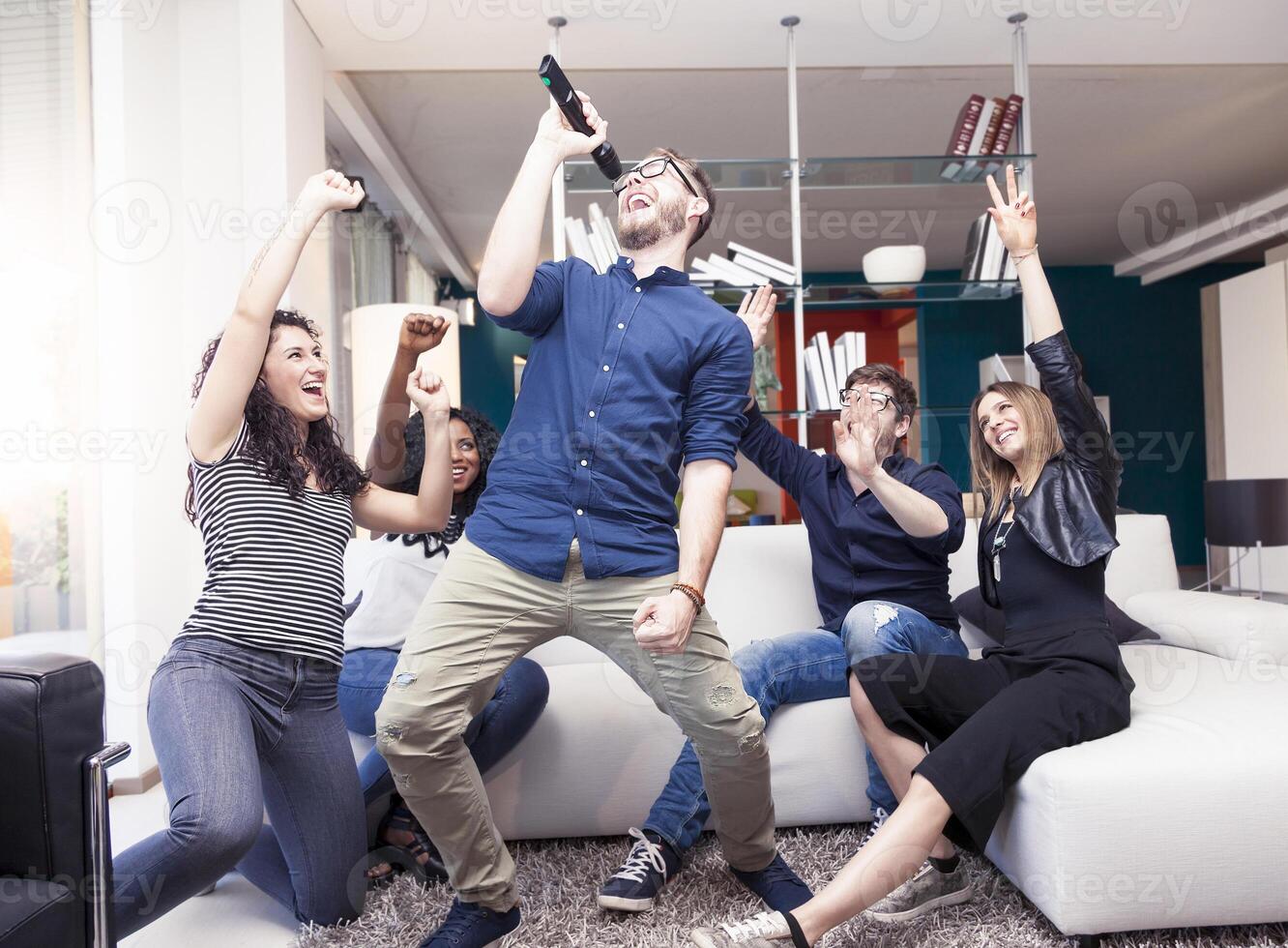 group of friends having fun at home singing a song together photo
