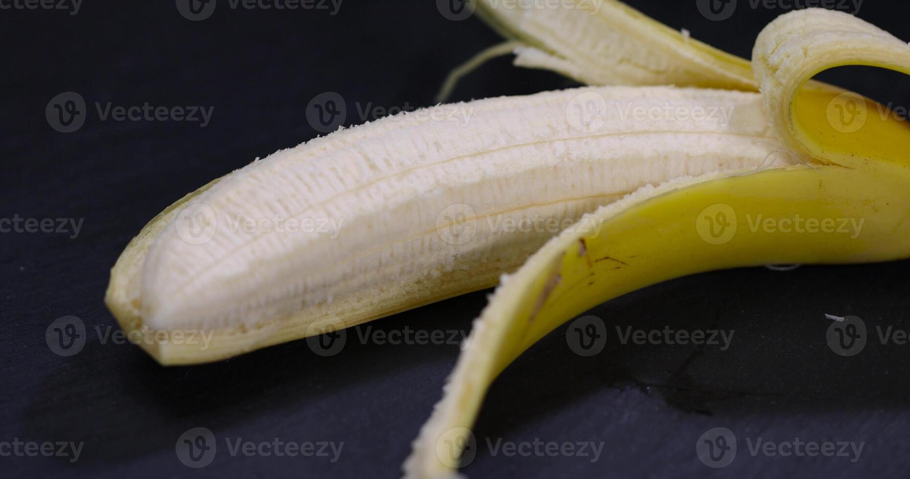 ripe and sweet yellow banana on a kitchen board made of black stone photo