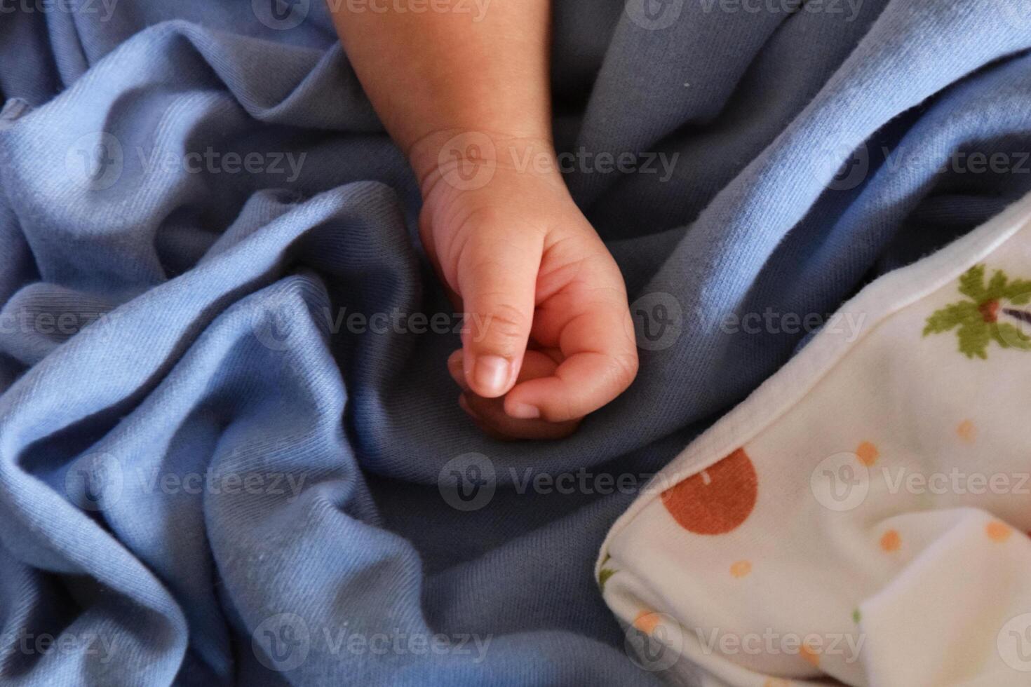 Baby hand on blue blanket closeup photo