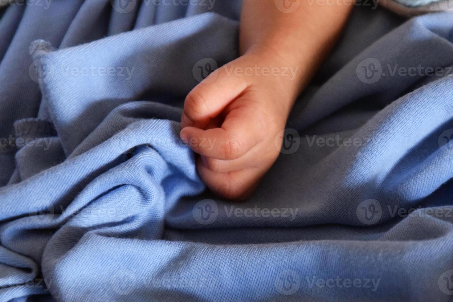 Tiny baby hand on soft fabric photo