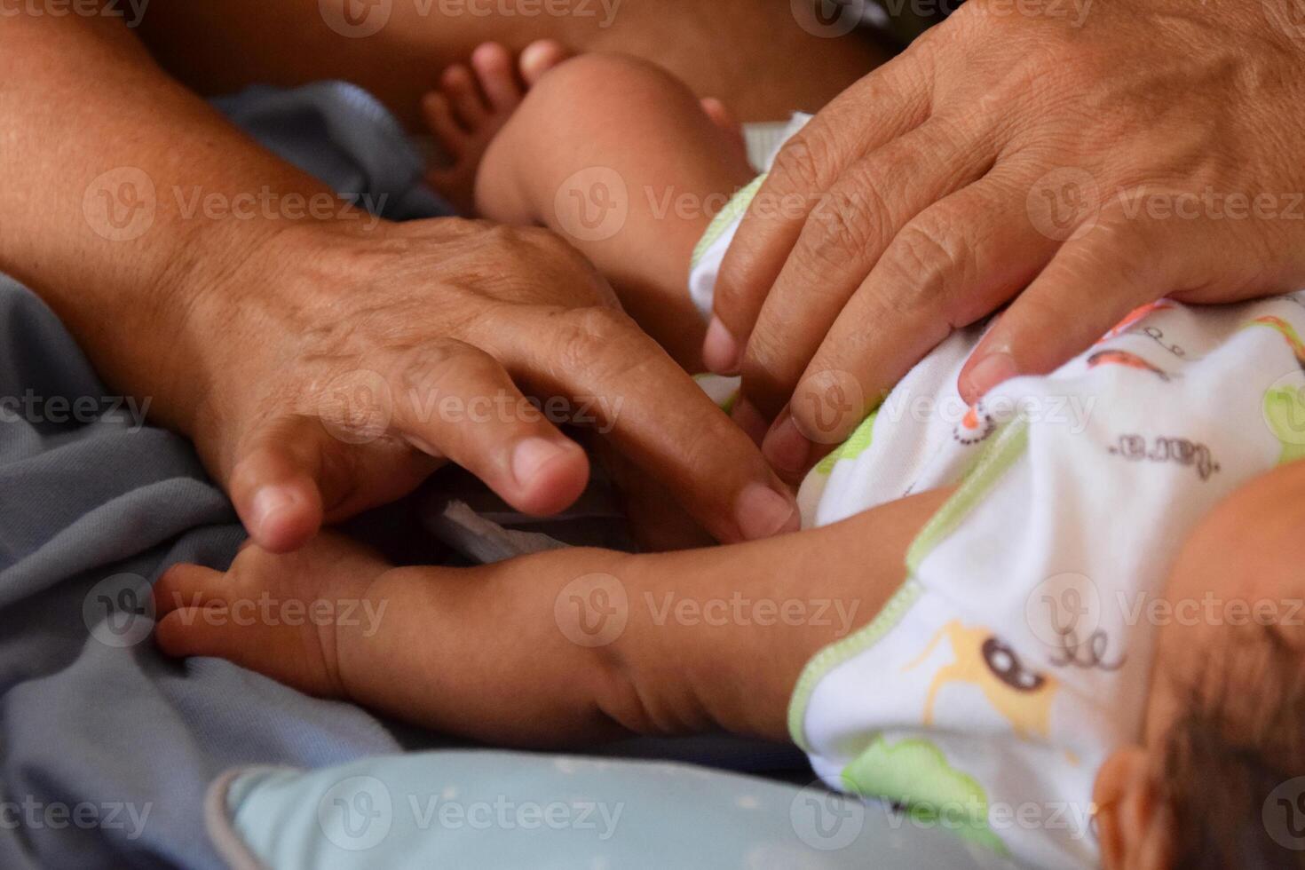Mother gently changing infant diaper at home photo