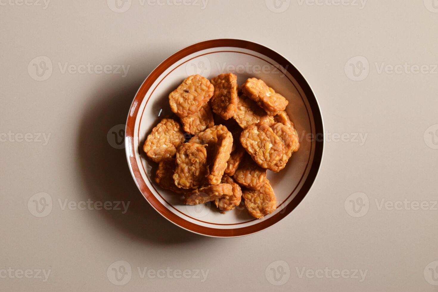 Top view of savory Indonesian fried tempeh on a plate photo