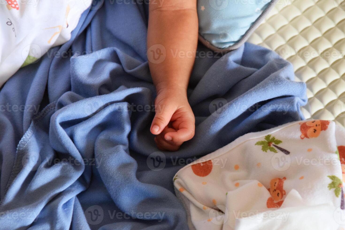 Close up of tiny baby hand on soft blue blanket photo