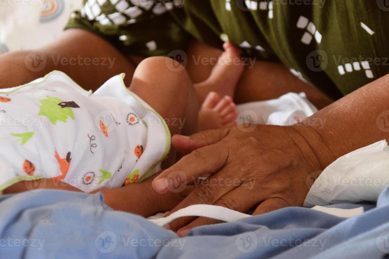 Asian mother cleaning and changing baby diaper photo