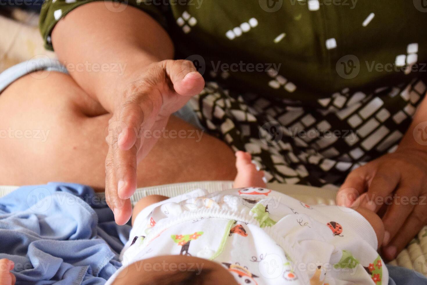 Hands of mother cleaning baby during diaper change photo