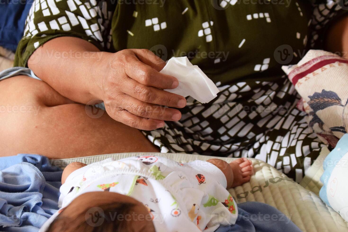 Baby diaper changing moment with Asian mother hands photo
