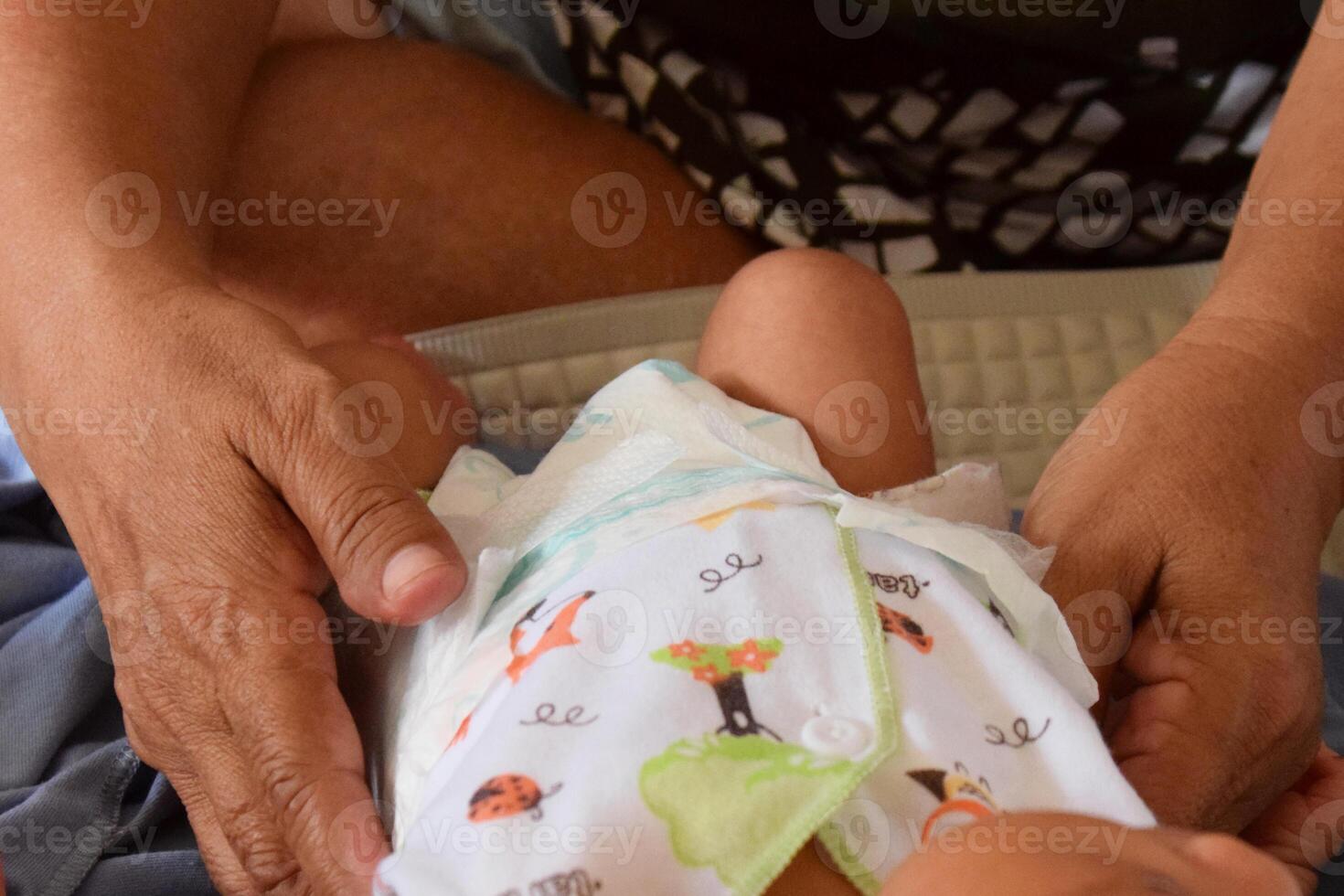 Hands of Asian mom cleaning baby with love photo