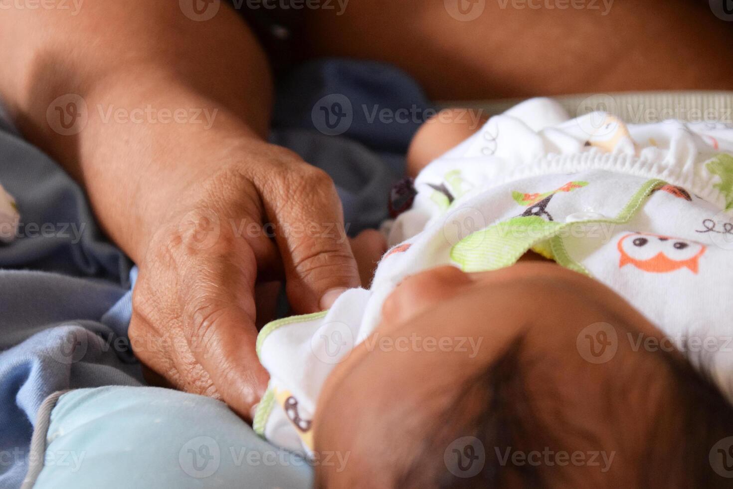 Asian mother caring for baby during diaper change photo