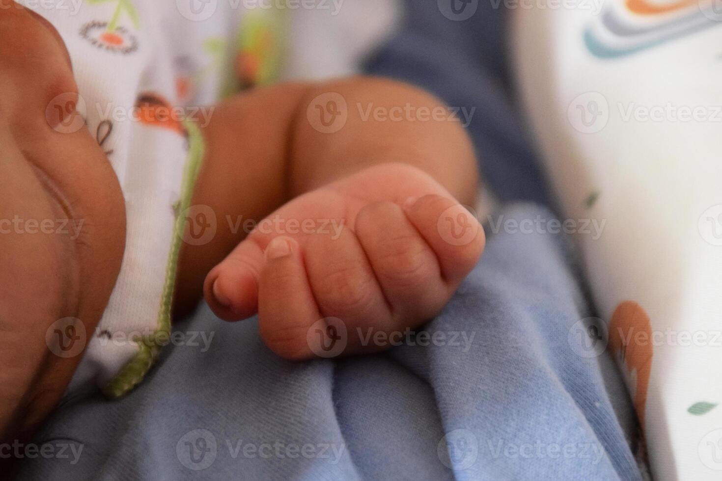 Small baby hands resting peacefully on mattress photo
