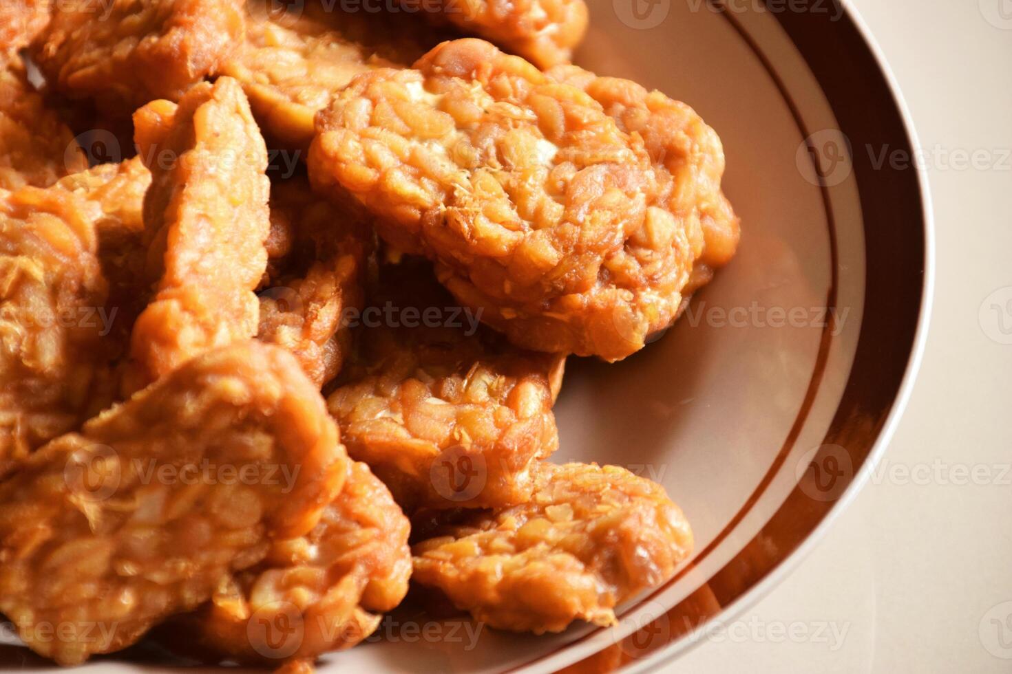 Savory fried tempeh on a plate, traditional Indonesian soybean food photo