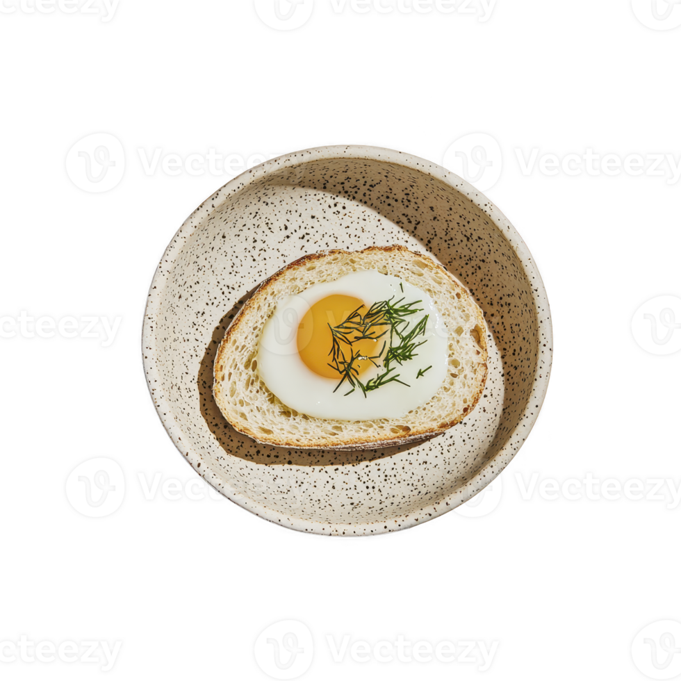 Fried egg with herbs on toast is served in speckled ceramic bowl, creating simple yet elegant breakfast presentation. dish combines rustic charm with modern touch png