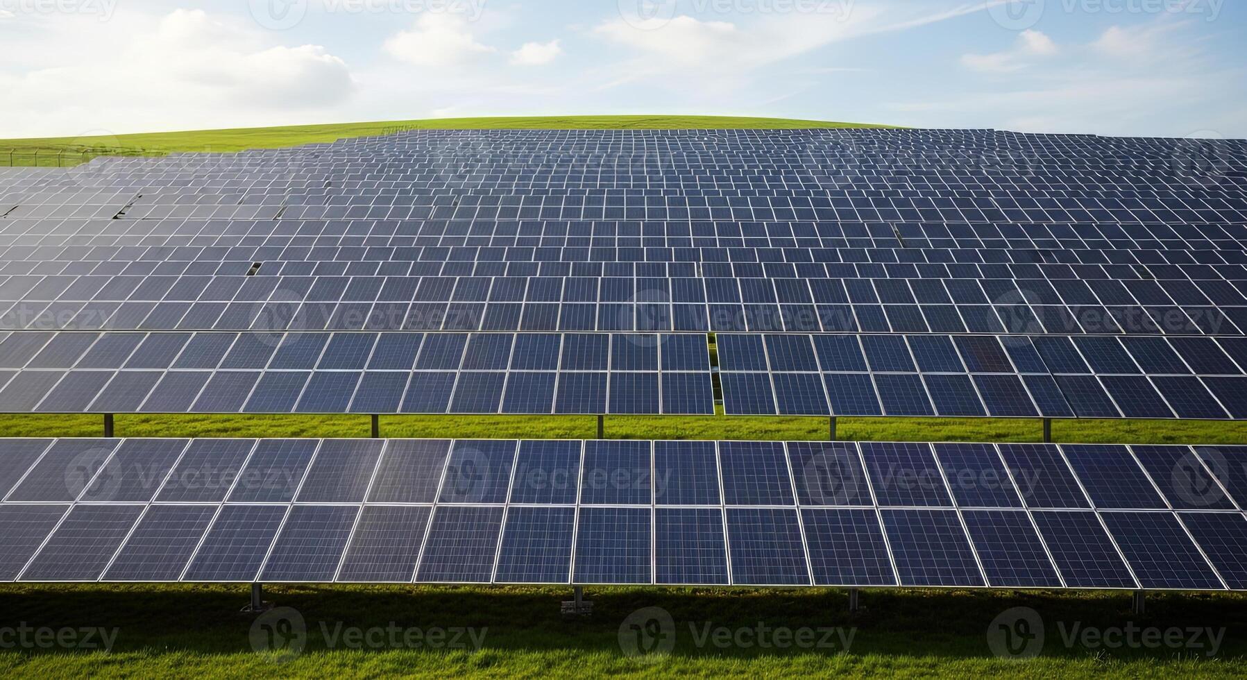 A wide expanse of solar panels stretches across a green field photo