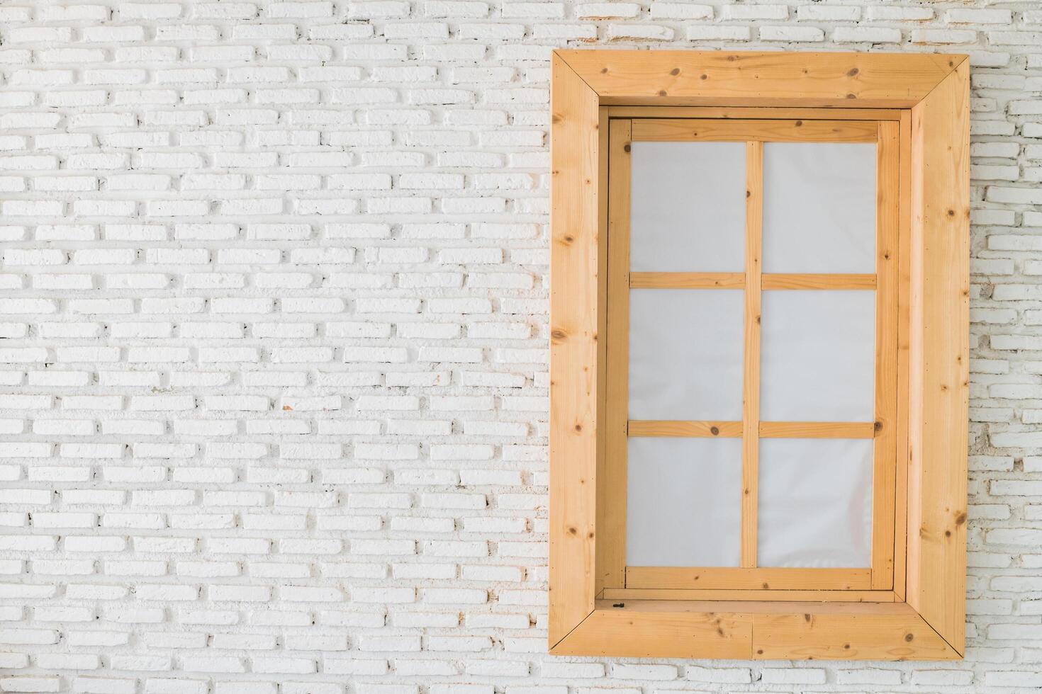 A wooden window on a white brick wall photo