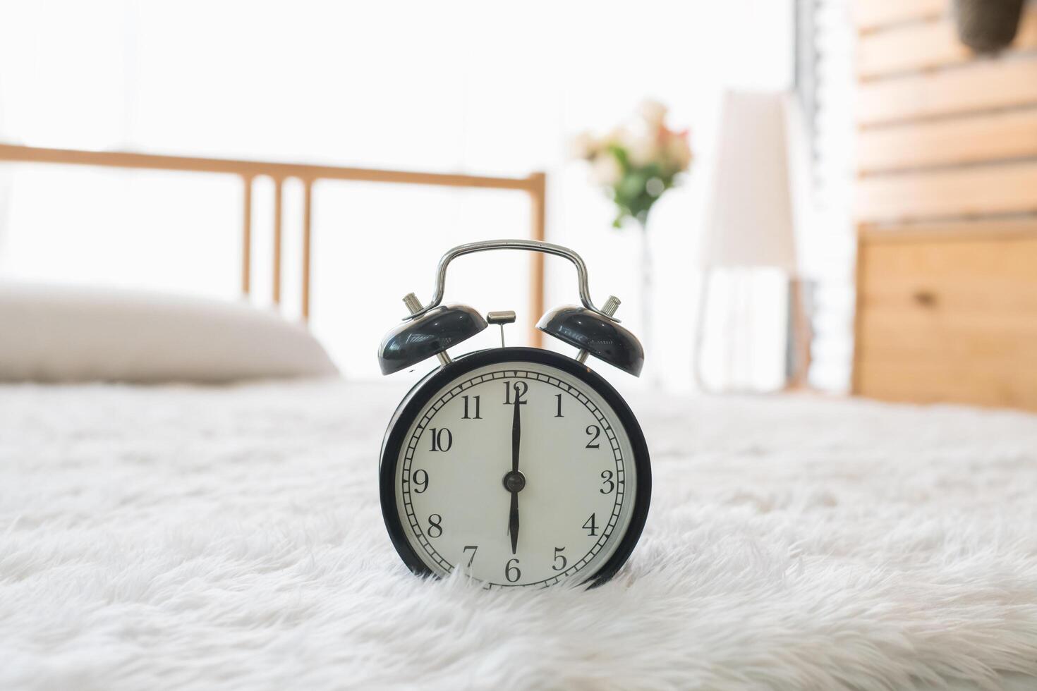 A clock is sitting on a bed in a bedroom photo