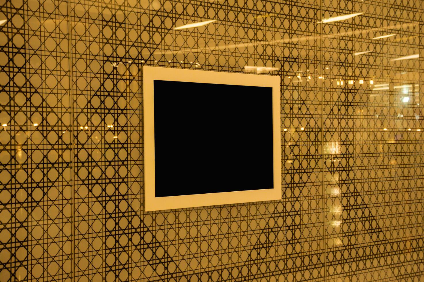 A black square frame is mounted on a wall photo