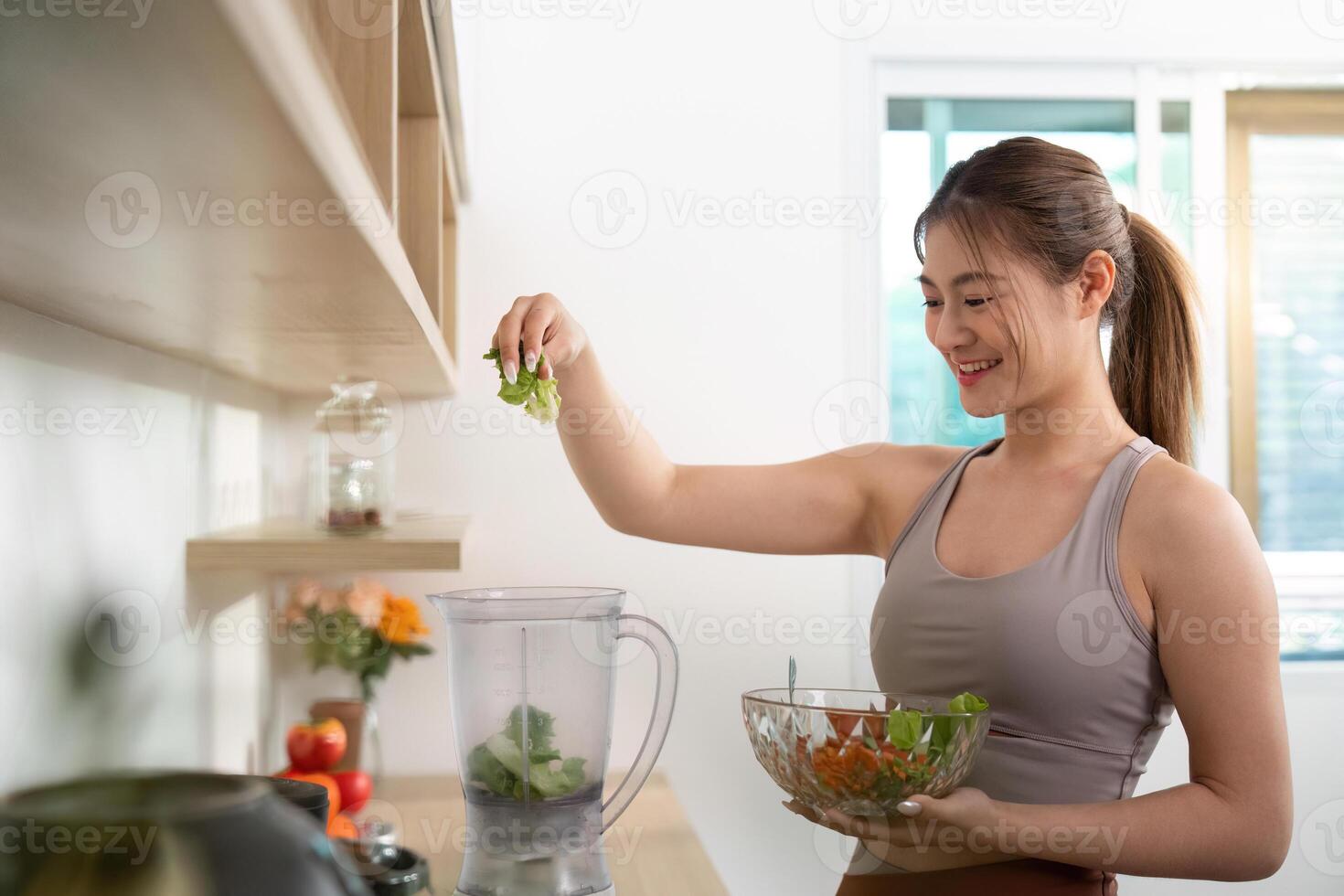 Woman blending healthy ingredients in kitchen photo