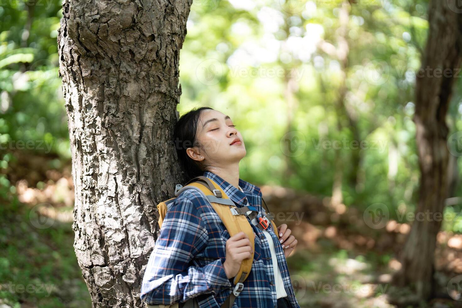 Woman resting against a tree photo
