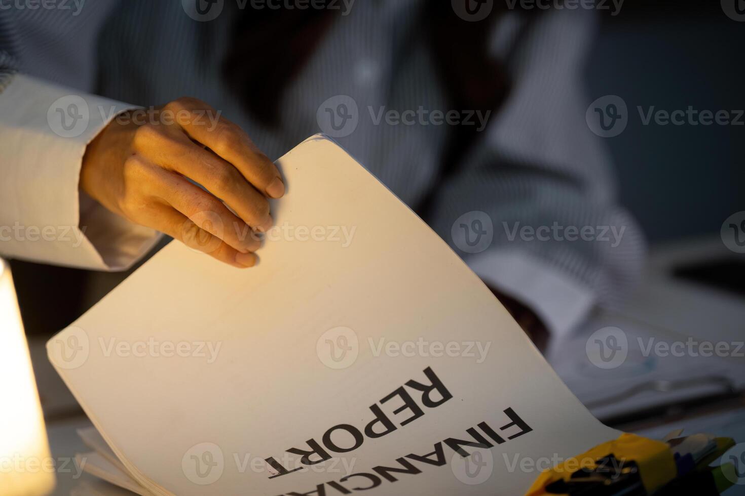 Late Night Review. Close-up of hand flipping through financial report. photo