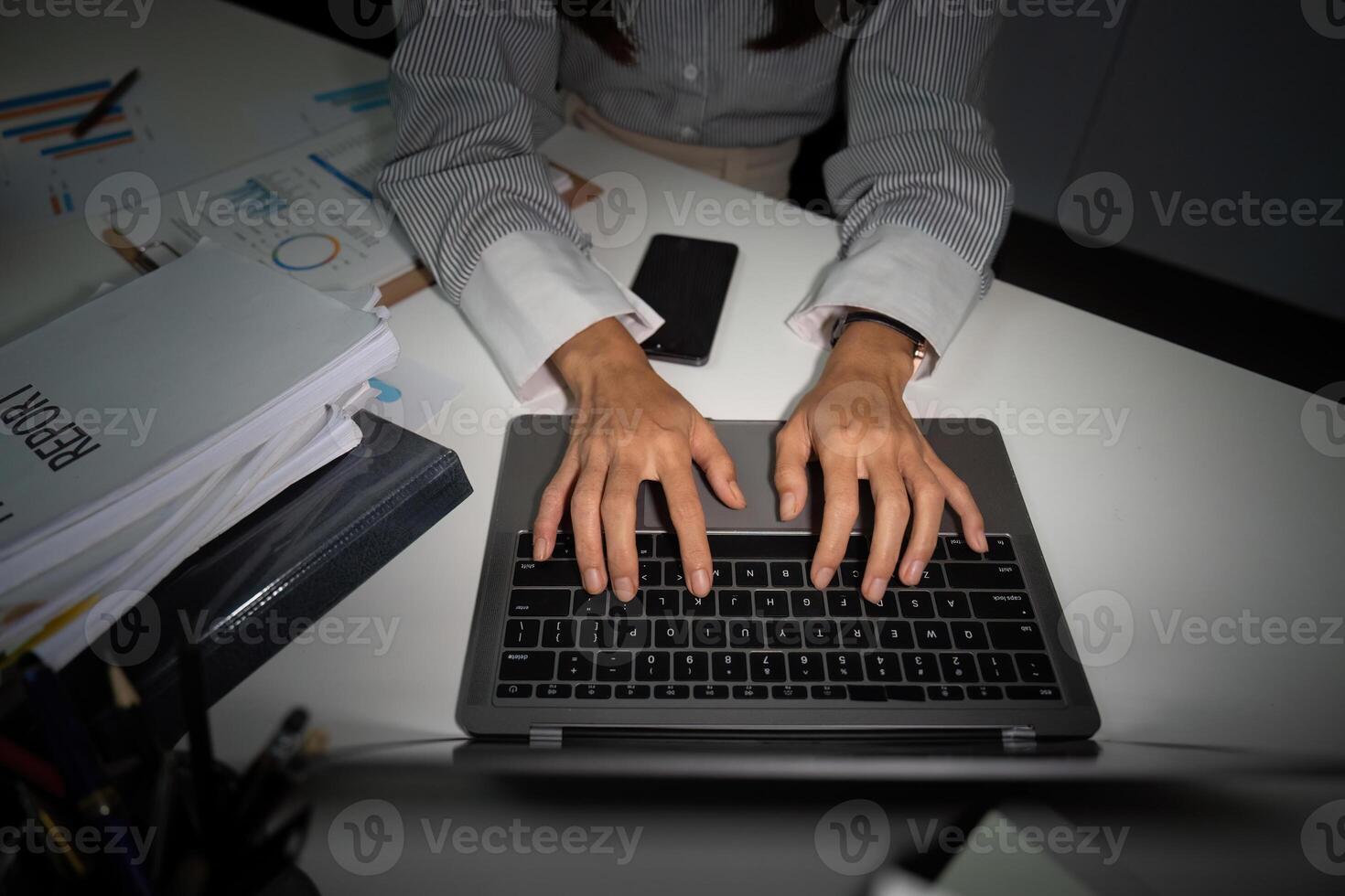 Late Night Typing. Close-up of hands typing on a laptop in an office. photo